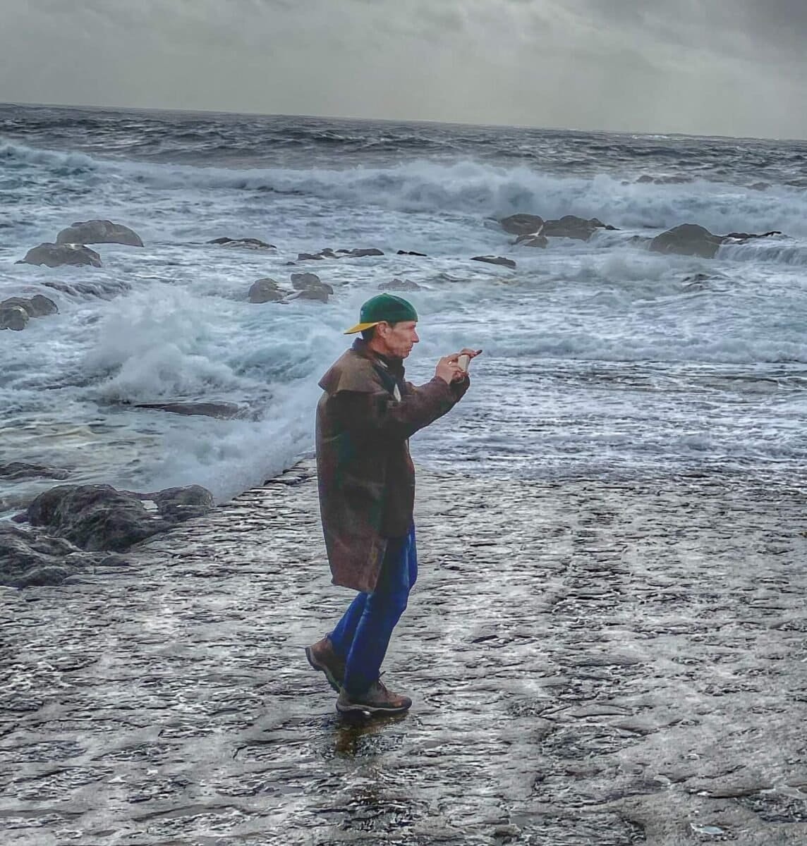 man photographing waves on a cloudy and cold day in the Azores