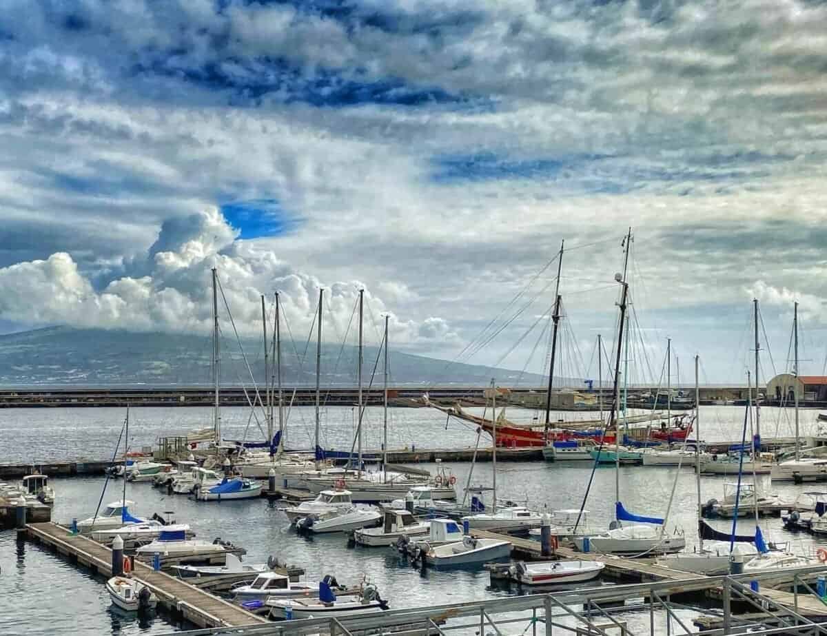 sailboats filling Horta's marina with a view of Pico mountain in the background on the island of Faial in the Azores