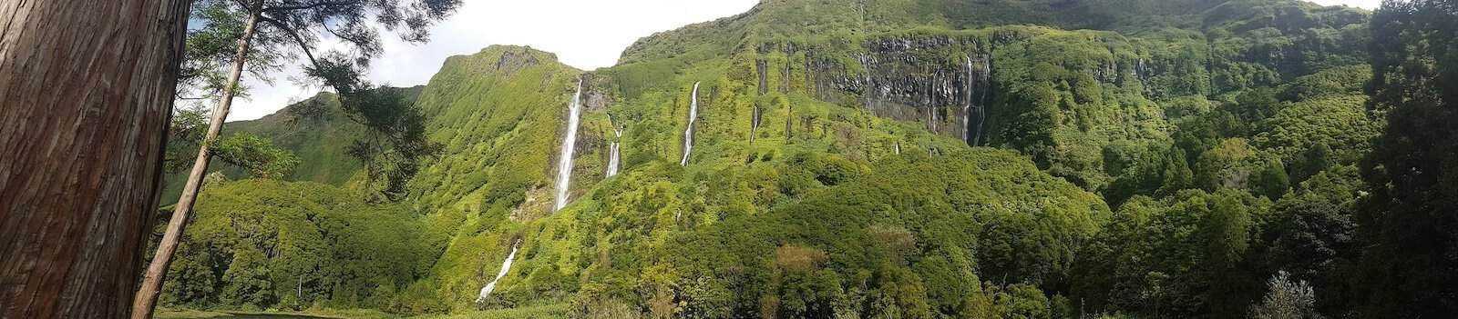 waterfalls cascade down lush cliffs at Poco da Ribeira on Flores in the Azores