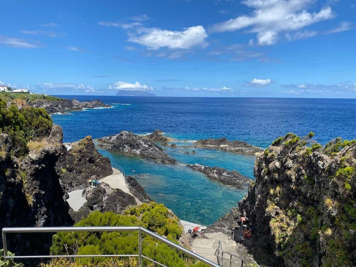 The large, clear natural pools of Santa Cruz das Flores with Corvo in the distance on the island of Flores in the Azores