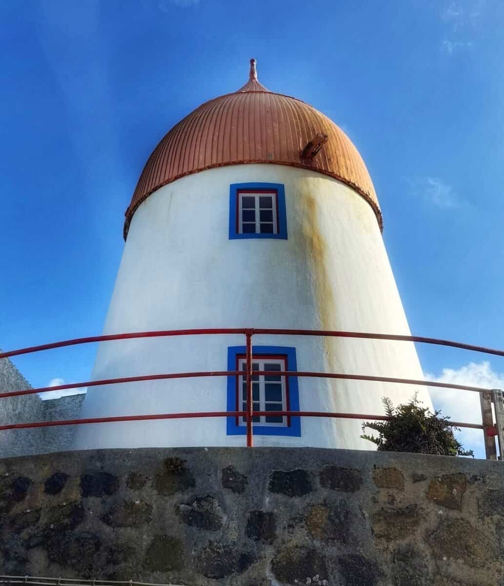 white windmill with red top and blue trim around windows on the island of Graciosa in Azores