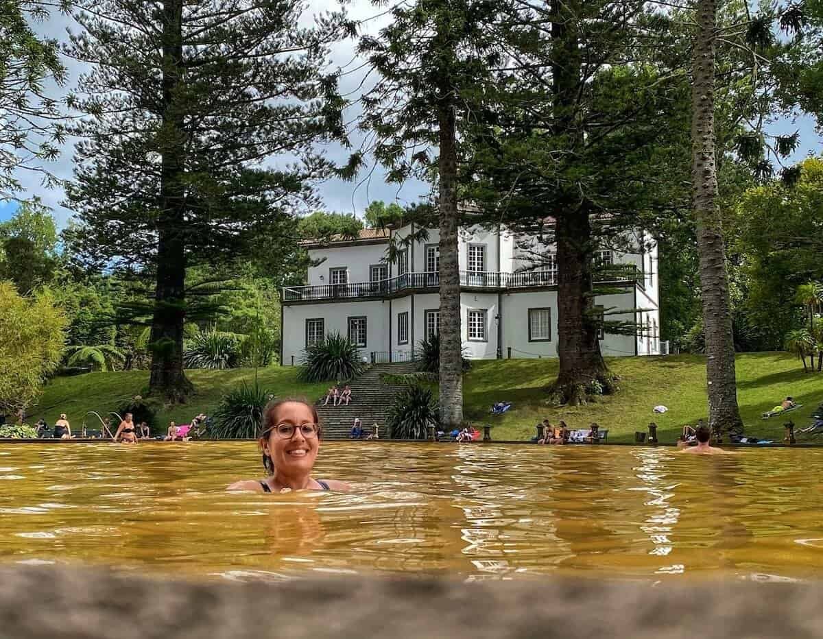 Woman bathing in golden, mineral-rich geothermal pool at Furnas on São Miguel in the Azores